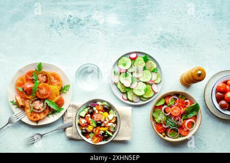 Insalate vegetariane fresche, posate a soffitto di un assortimento. Varietà di piatti e ciotole con verdure verdi. Cibo sano, con spazio di copia Foto Stock