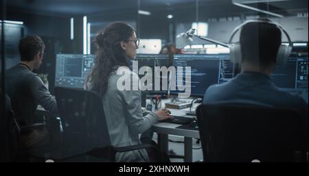 Team di diversi sviluppatori di software multietnici che lavorano su computer, programmazione di codice avanzato, gestione di progetti di intelligenza artificiale online per servizi cloud innovativi basati su Internet Foto Stock