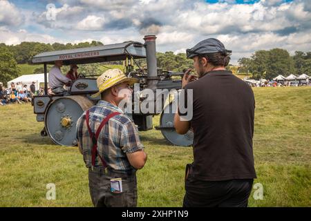 Storrington / Regno Unito - 13 luglio 2024: Due appassionati di vapore chiacchierano con un rullo a vapore Wallis & Steevens del 1936 alla Sussex Steam Fair, Parham, Storring Foto Stock