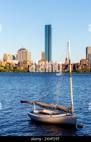 Vista sul fiume Charles verso il quartiere Back Bay di Boston. Barca a vela singola in primo piano. Foto Stock