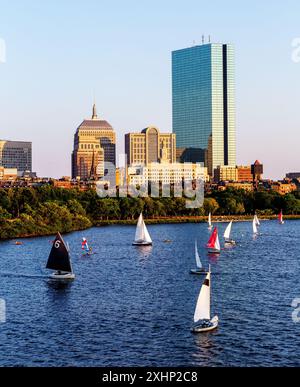 Boston, Massachusetts. Tramonto sullo skyline di Boston Back Bay, tra cui la John Hancock Tower e il fiume Charles con barche a vela Foto Stock