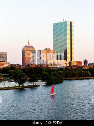 Boston, Massachusetts. Tramonto sullo skyline di Boston Back Bay, tra cui la John Hancock Tower e il fiume Charles con un sailbo Foto Stock