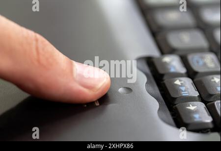 Uomo che utilizza un modulo scanner di impronte digitali integrato in un computer portatile, che fa scorrere le dita sul dettaglio del sensore di impronte digitali in primo piano, una sola persona. Autenticazione biometrica Foto Stock