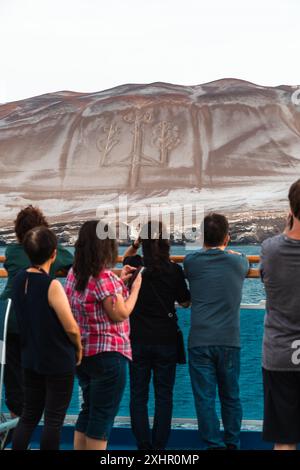 Paracas, Perù - 19 marzo 2019: I turisti osservano l'antico geoglifo Candelabro de Paracas su una collina sabbiosa. Foto Stock