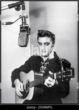 ELVIS PRESLEY iconico pop star negli anni '1950 all'inizio della sua carriera, cantando e suonando la sua chitarra in uno studio di registrazione RCA Victor con microfono dell'epoca. Hollywood USA 1955 Foto Stock