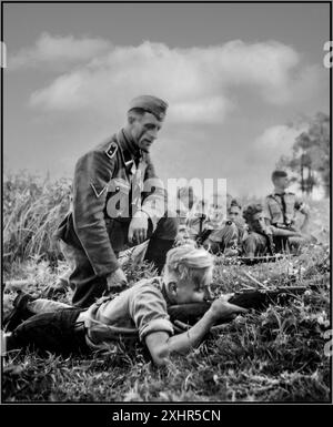 Seconda guerra mondiale Wehrmacht, soldato della Germania nazista, addestrando un adolescente in uniforme Hitlerjugend (HJ) come sparare a un fucile durante il loro viaggio in Russia. Il ragazzo adolescente è uno studente della scuola Adolf Hitler in Turingia. Seconda guerra mondiale seconda guerra mondiale 1942 Foto Stock