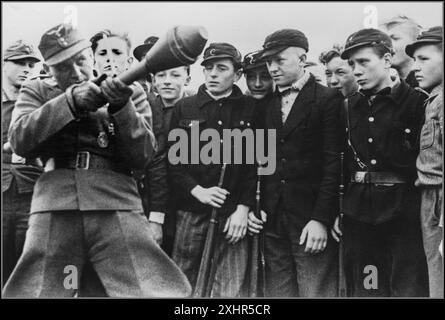 PANZERFAUST WW2 1945 soldato nazista della Wehrmacht dimostra il razzo anticarro Panzerfaust, ai ragazzi della Gioventù hitleriana, per addestrarli in un ultimo tentativo di frenare l'avanzata dell'esercito russo sovietico Berlino Germania nazista. Seconda guerra mondiale la battaglia di Berlino Foto Stock