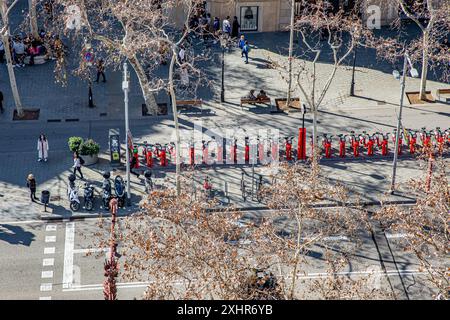 Linea di biciclette elettriche ecologiche a noleggio pubblico in una strada di Barcellona in Spagna Foto Stock