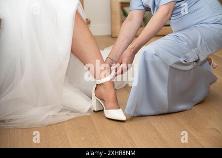 La madre della sposa assiste nel carico delle scarpe prima del matrimonio. Foto Stock