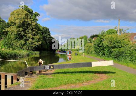 Paesaggio con strette barche ormeggiate e cancello a serratura sul canale Kennett & Avon a Devizes. Data: Luglio 2024. Estate. Foto Stock