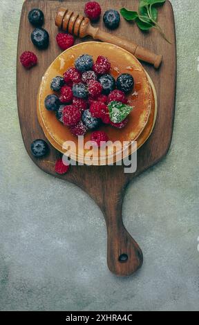 Colazione, pancake con frutti di bosco e miele, vista dall'alto, fatti in casa, niente persone Foto Stock