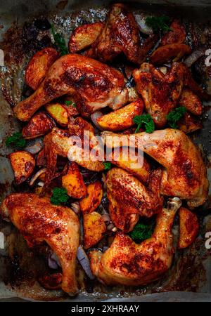 Cosce di pollo arrosto con patate e cipolle in forno, fatte in casa. Niente persone Foto Stock