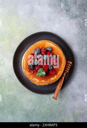 Colazione, pancake con frutti di bosco e miele, vista dall'alto, fatti in casa, niente persone Foto Stock