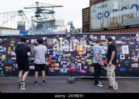 I visitatori guardano le foto degli anni passati su una recinzione di costruzione al Melt Festival di Ferropolis il 12 luglio 2024. Dopo un totale di 27 anni, il Foto Stock