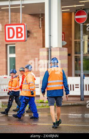 Operai edili in gilet e caschi protettivi di fronte a un edificio DB sulla strada, lo scavo del ponte ferroviario Hermann Hesse, Calw Foto Stock