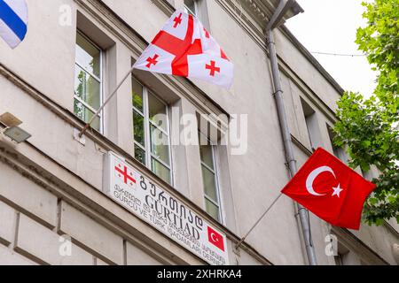 Tbilisi, Georgia - 21 GIUGNO 2024: Bandiere turche e georgiane appese alla finestra, ufficio dell'Unione degli uomini d'affari georgiani e turchi in TBI Foto Stock