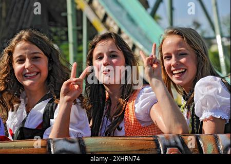 Tre simpatiche ragazze in Dirndls mostrano il segno Victoty, il gesto della mano V per la Vittoria, la vittoria, il giro in acqua bianca, il giro all'Oktoberfest, Wies'n, Wiesn Foto Stock