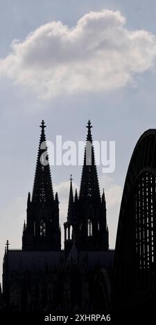 Le torri della cattedrale di Colonia e il ponte Hohenzollern come una sagoma con una nuvola, Colonia, Renania settentrionale-Vestfalia, Germania Foto Stock