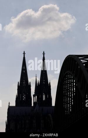 Le torri della cattedrale di Colonia e il ponte Hohenzollern come una sagoma con una nuvola, Colonia, Renania settentrionale-Vestfalia, Germania Foto Stock