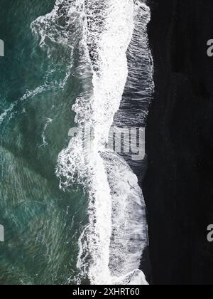 Vista dall'alto con il drone dalla spiaggia di Reynisfjara con sabbia nera in Islanda Foto Stock