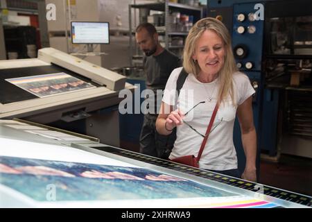Caroline Furneaux fotografa su stampa all'EBS Verona, guardando il suo primo libro stampato, le madri che avrei potuto avere. Sta verificando la qualità di stampa dell'immagine di copertina. Verona, Italia giugno 2024 2020s HOMER SYKES Foto Stock