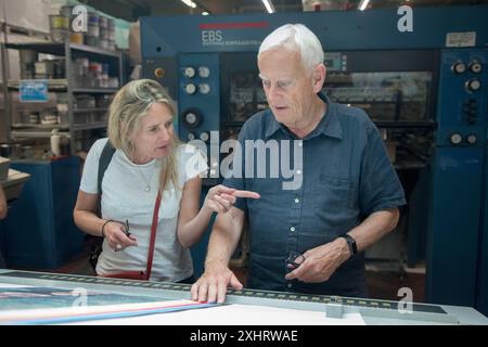 Caroline Furneaux fotografa e Dewi Lewis (Editore) sulla stampa all'EBS Verona guardando il suo primo libro stampato, The Mothers i might have have. Stanno verificando la qualità di stampa dell'immagine di copertina. Verona, Italia giugno 2024 2020s HOMER SYKES Foto Stock