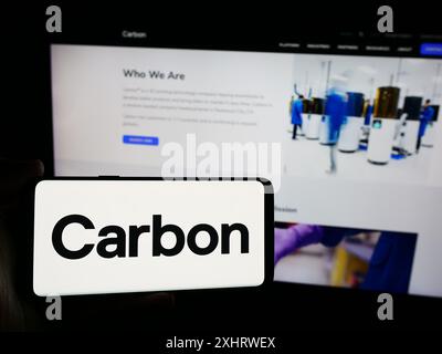 Persona che possiede uno smartphone con il logo della società di stampa 3D statunitense Carbon Inc. Davanti al sito Web. Mettere a fuoco il display del telefono. Foto Stock