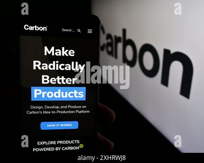 Persona che detiene un cellulare con la pagina Web della società di stampa 3D statunitense Carbon Inc. Davanti al logo aziendale. Messa a fuoco al centro del display del telefono. Foto Stock