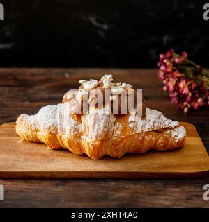 Croissant al cioccolato appena sfornati su sfondo di legno. Foto Stock