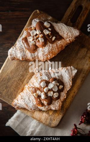 Croissant al cioccolato appena sfornati su sfondo di legno. Foto Stock