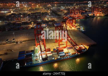LIANYUNGANG, CINA - 15 LUGLIO 2024 - le navi cargo scaricano i container presso il terminal container del porto di Lianyungang, nella provincia di Jiangsu nella Cina orientale, luglio Foto Stock