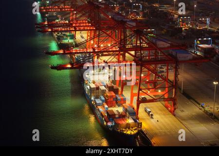 LIANYUNGANG, CINA - 15 LUGLIO 2024 - le navi cargo scaricano i container presso il terminal container del porto di Lianyungang, nella provincia di Jiangsu nella Cina orientale, luglio Foto Stock