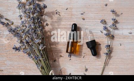 Fiori di lavanda secchi con contagocce in vetro di olio essenziale naturale. Bottiglia di vetro sano aromaterapia a base di erbe organiche. Estratto di fragranze per la casa. Cura della bellezza Foto Stock