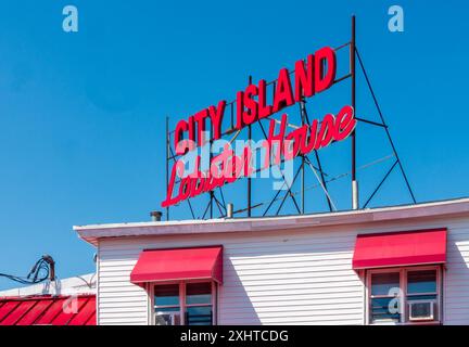 Bronx, New York - Stati Uniti - 13 luglio 2024 Vista panoramica dell'iconico cartello rosso City Island Lobster House che accoglie i visitatori mentre attraversano City Island. Foto Stock