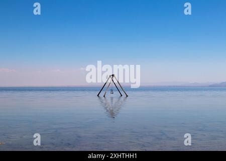 Un'altalena solitaria sorge nelle acque del Mare di Salton, nella California meridionale. Alla spiaggia abbandonata di Bombay. Foto di alta qualità Foto Stock