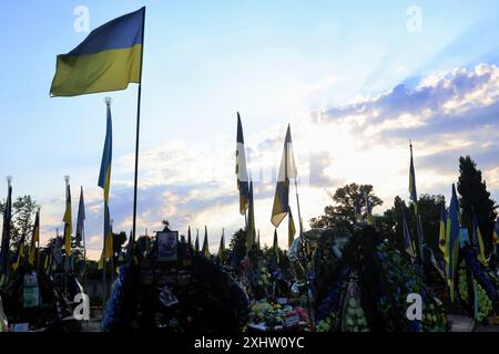 Kiev, Ucraina. 15 luglio 2024. Bandiere ucraine battono bandiera sulle tombe dei soldati ucraini nel cimitero di Kiev. Decine di soldati dell'esercito ucraino morti in battaglie contro la Russia sono sepolti nel vicolo dei soldati del cimitero. (Foto di Aleksandr Gusev/SOPA Images/Sipa USA) credito: SIPA USA/Alamy Live News Foto Stock