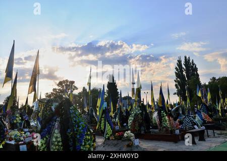 Kiev, Ucraina. 15 luglio 2024. Bandiere ucraine battono bandiera sulle tombe dei soldati ucraini nel cimitero di Kiev. Decine di soldati dell'esercito ucraino morti in battaglie contro la Russia sono sepolti nel vicolo dei soldati del cimitero. (Foto di Aleksandr Gusev/SOPA Images/Sipa USA) credito: SIPA USA/Alamy Live News Foto Stock