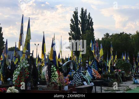 Kiev, Ucraina. 15 luglio 2024. Bandiere ucraine battono bandiera sulle tombe dei soldati ucraini nel cimitero di Kiev. Decine di soldati dell'esercito ucraino morti in battaglie contro la Russia sono sepolti nel vicolo dei soldati del cimitero. (Foto di Aleksandr Gusev/SOPA Images/Sipa USA) credito: SIPA USA/Alamy Live News Foto Stock