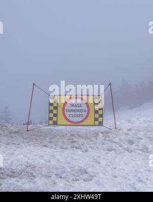 "Chiuso" è un segnale di divieto. Stazione sciistica, neve bagnata, ghiaccio, nebbia fitta, visibilità molto scarsa. La pista da sci è chiusa. Foto Stock