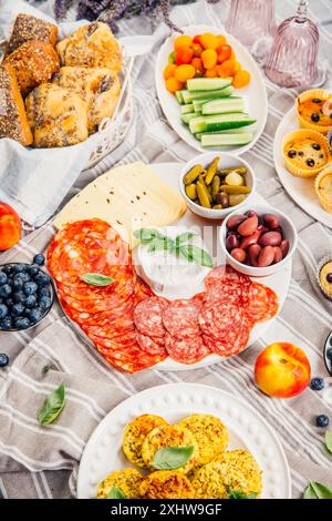 Picnic, antipasti e vassoio di formaggi e carne con muffin dolci e salati e frutta Foto Stock