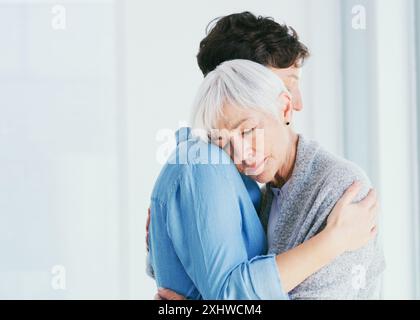 Donne, mamma anziana e triste abbracciano con empatia per la salute mentale, la depressione e insieme per il sostegno a casa. Madre anziana, figlia e abbraccio per Foto Stock