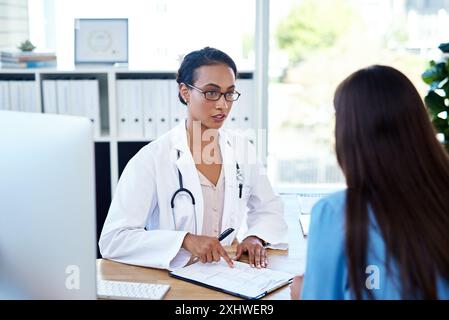 Ospedale, scartoffie e medico con paziente per consulenza, servizio medico e diagnosi in clinica. Assistenza sanitaria, cardiologia e persona con donna con Foto Stock