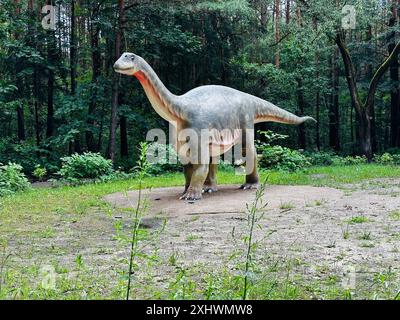 Figura realistica del dinosauro Vulcanodon nella foresta di Kazimierz, Sosnowiec. L'ambiente del parco mette in risalto il dinosauro nel suo ambiente naturale Foto Stock