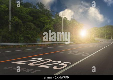 2025,il nuovo anno 2025 o l'inizio del concetto della parola 2025 è scritto sulla strada in mezzo alla strada asfaltata con un tramonto mountai Foto Stock