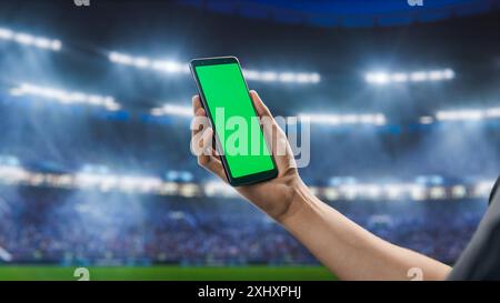Sport Stadium Championship: Smartphone Chroma Key con schermo verde. Evento sportivo con i tifosi che fanno il tifo per la squadra preferita per vincere il campionato. Modello Copyspace per primi piani POV isolato Foto Stock