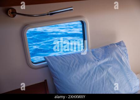 Yacht interno. Interno dello yacht a vela con finestra e letto Foto Stock