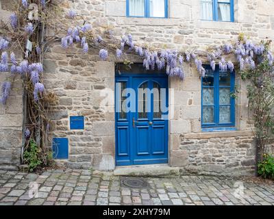 porte blu e vecchia casa con fiori di glicine a franch Foto Stock