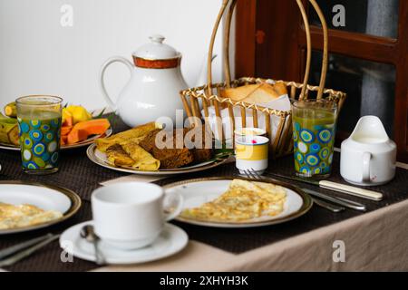 Colazione tradizionale dello Sri Lanka a Bentota, Sri Lanka, con omelette, tè, caffè, bibita verde, pancake al cocco e pasticcini. Foto Stock