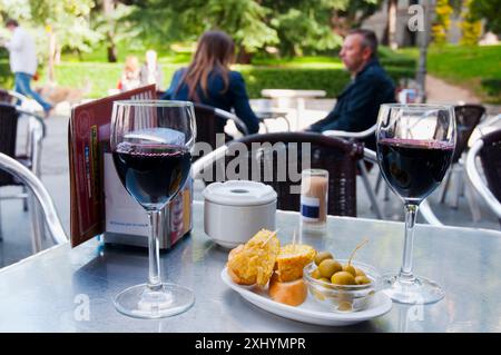 Due bicchieri di vino rosso con tipica tapa in terrazza. Madrid, Spagna. Foto Stock