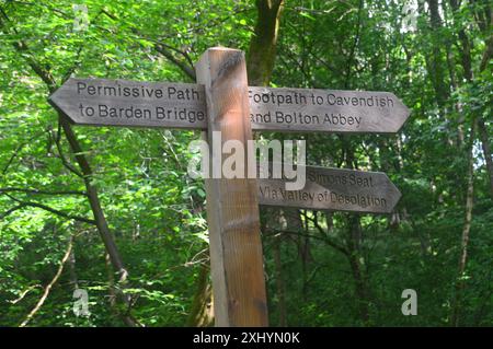 Cartello in legno per Barden Bridge, Cavendish, Simon's Seat e Valley of Desolation sul sentiero pedonale Dales Way a Bolton Abbey Woods nello Yorkshire Dales Foto Stock